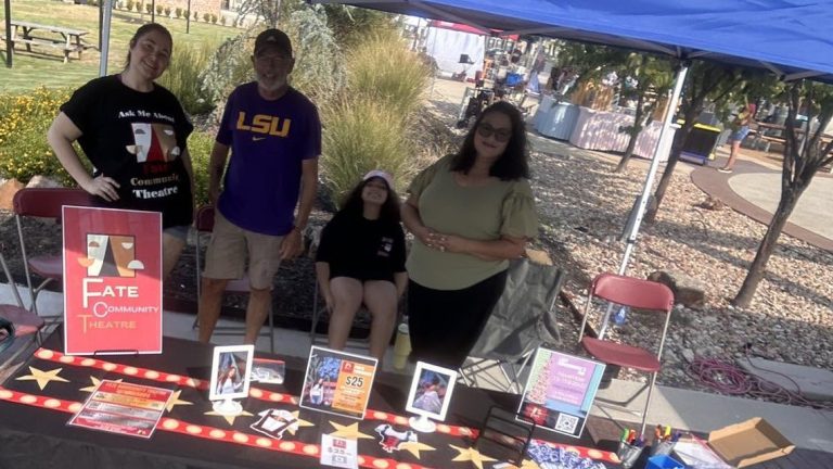 Fate Community Theatre volunteers staff the company's information table at a community event