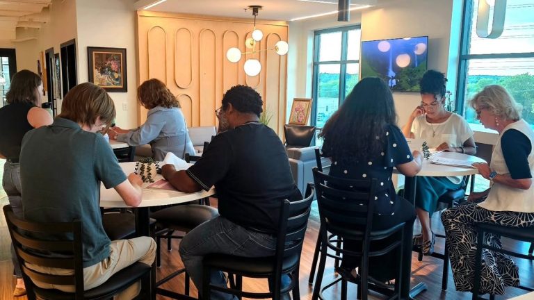 Actors read scripts around café tables during a Lady Windermere's Fan read-through